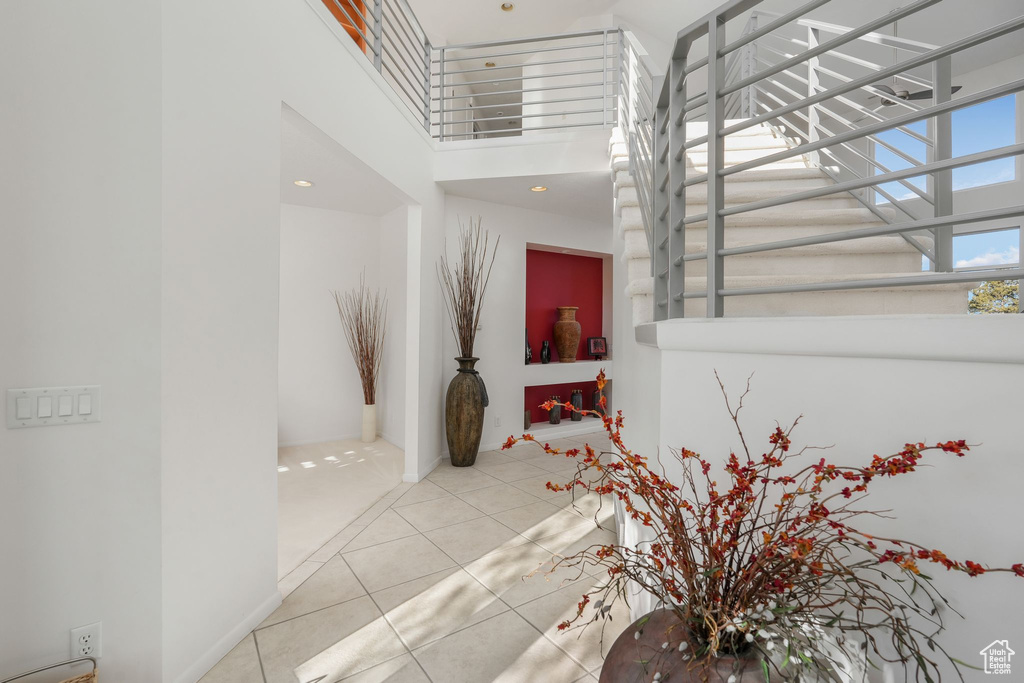 Stairway featuring a high ceiling and tile patterned flooring