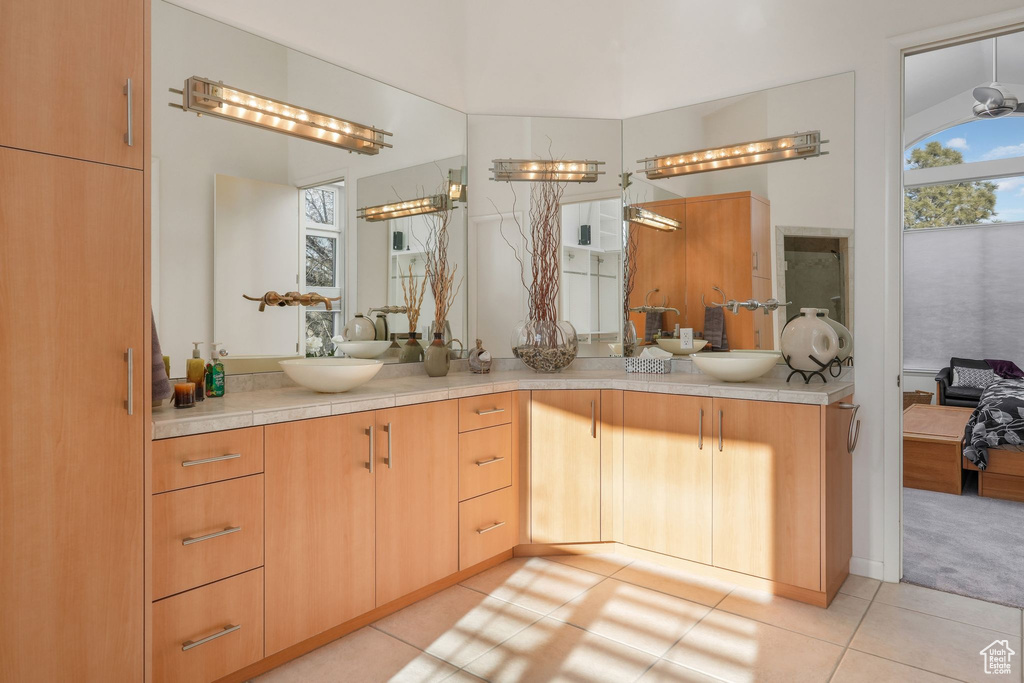 Bathroom featuring double vanity, tile patterned floors, and connected bathroom