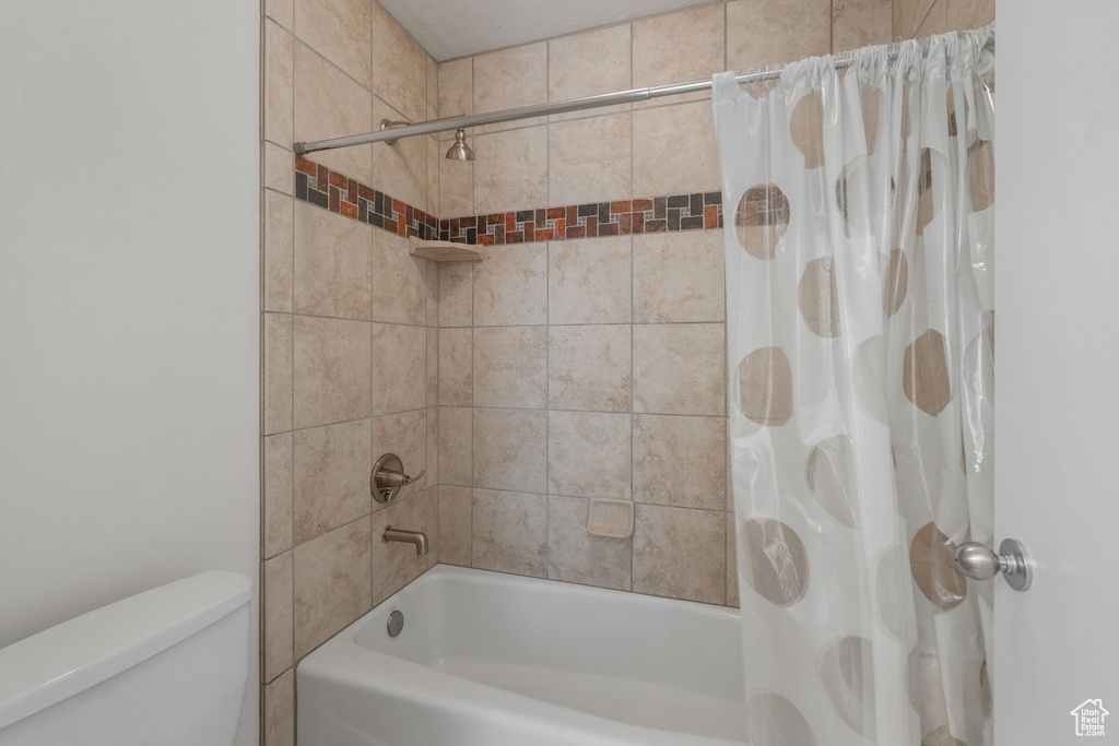 Bathroom with shower / tub combo with curtain and toilet