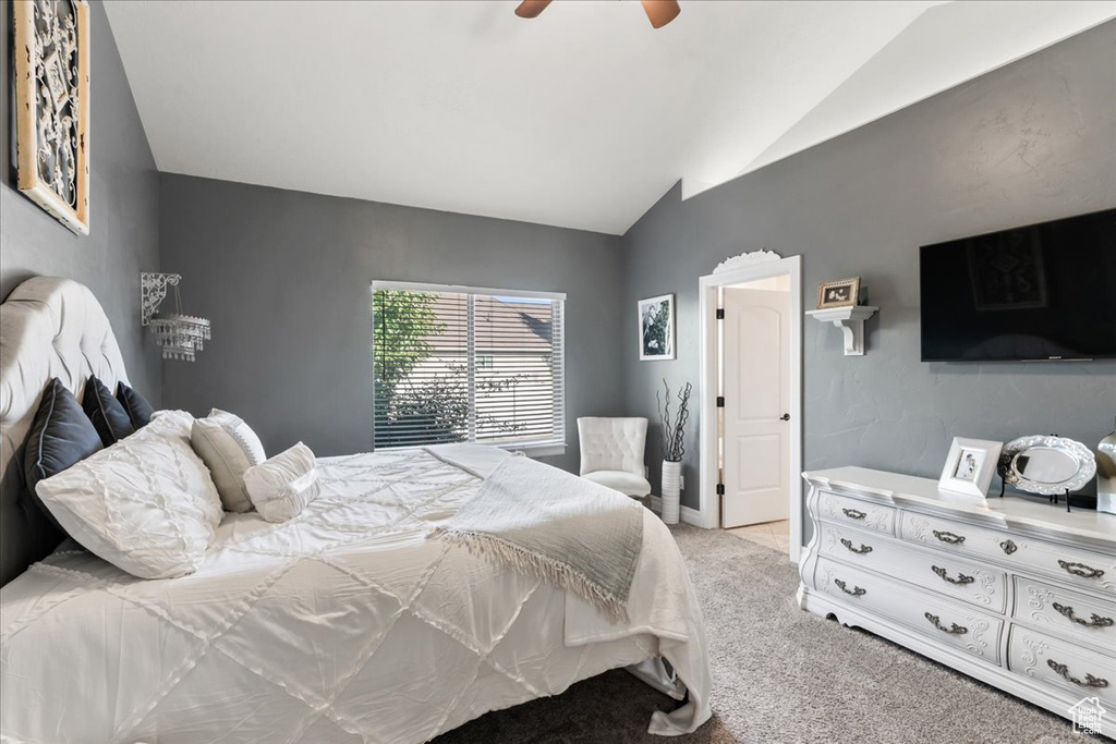 Bedroom featuring vaulted ceiling, light carpet, and ceiling fan