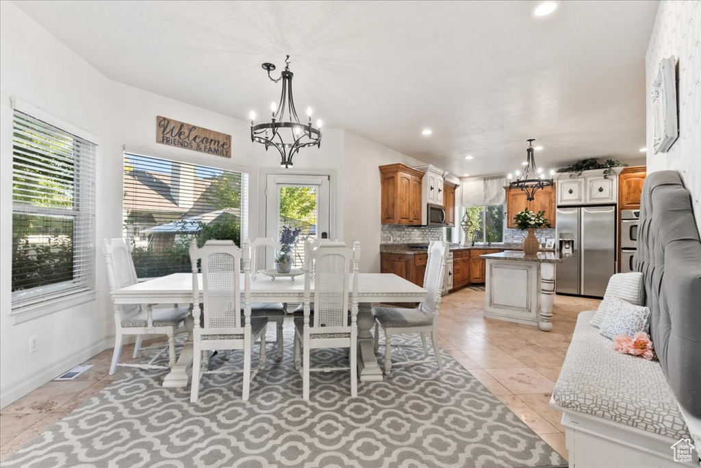 Dining space featuring a chandelier, recessed lighting, light tile patterned floors, and baseboards
