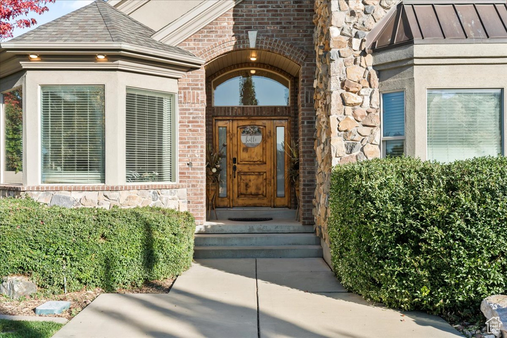 Property entrance featuring brick siding and stone siding