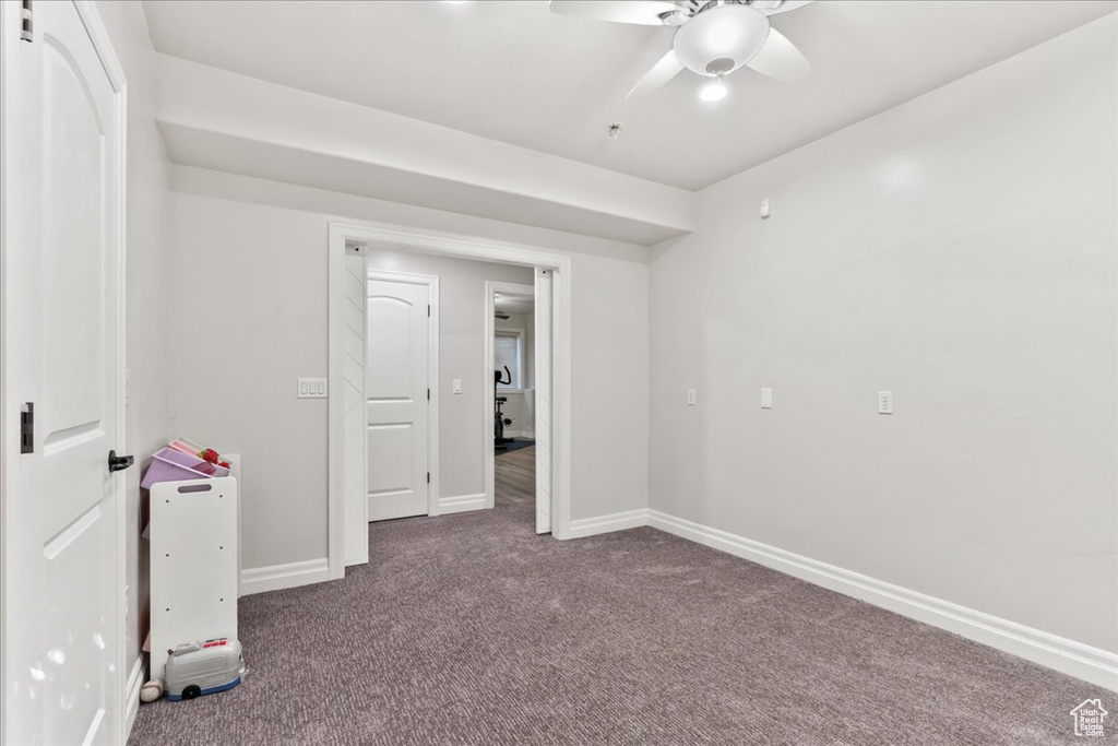 Unfurnished bedroom with carpet floors, baseboards, and a ceiling fan