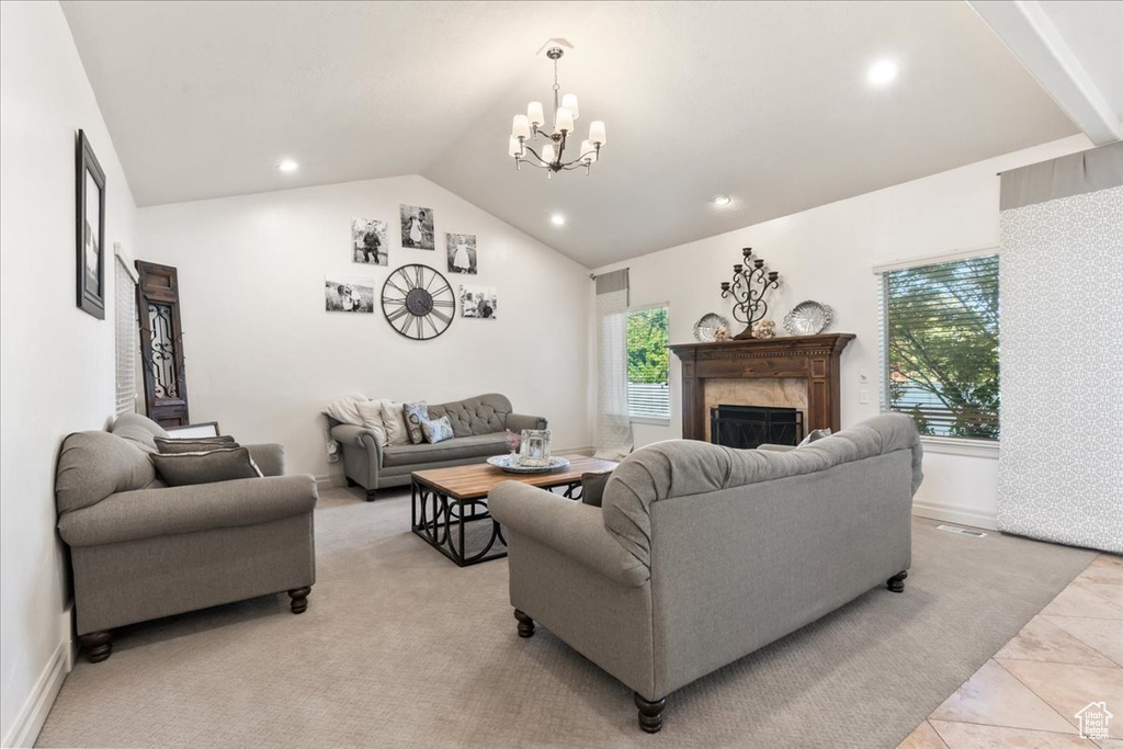 Living room featuring lofted ceiling, a chandelier, a premium fireplace, recessed lighting, and baseboards