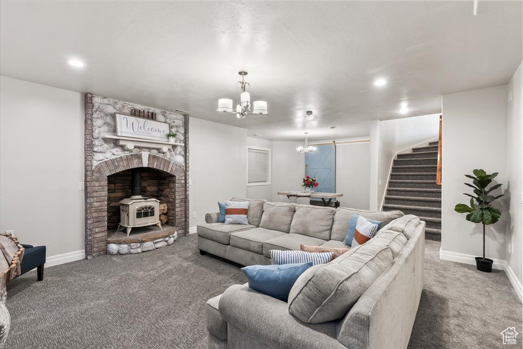 Carpeted living room featuring a chandelier, stairway, a wood stove, baseboards, and recessed lighting