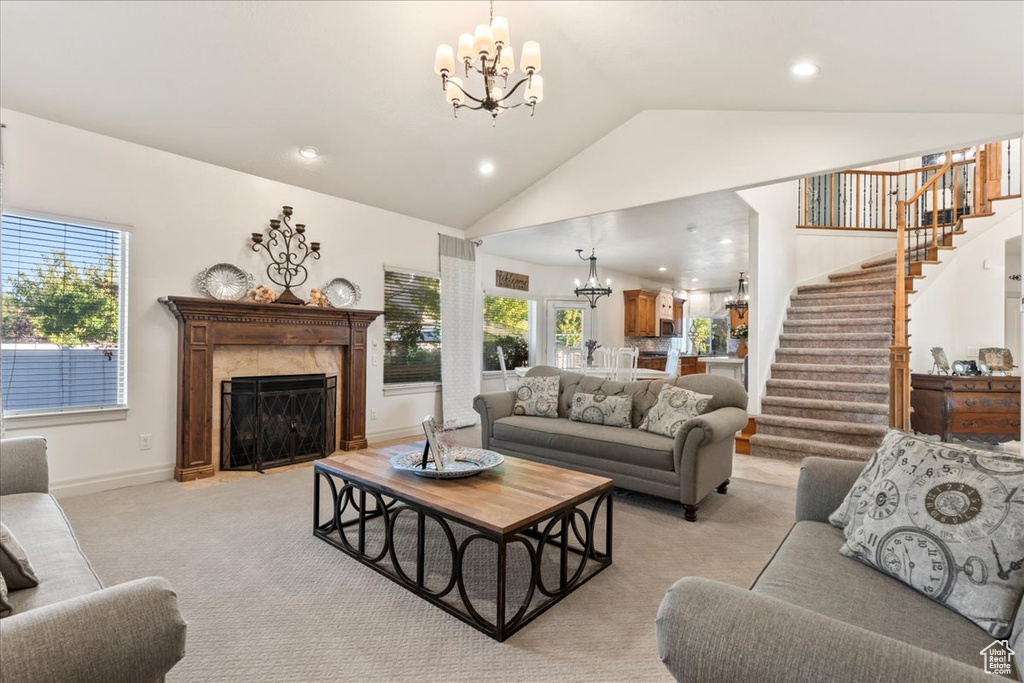 Living area with a chandelier, stairway, light carpet, a premium fireplace, and recessed lighting