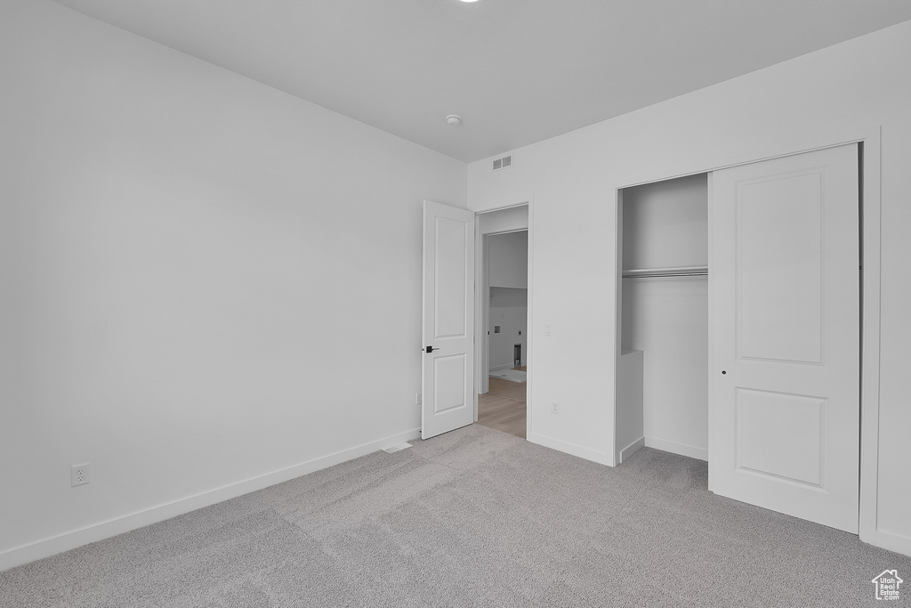 Unfurnished bedroom with carpet floors, baseboards, and a closet