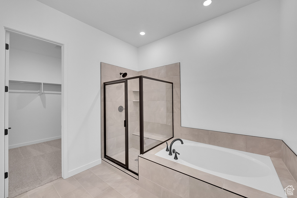 Full bathroom featuring a bath, a spacious closet, a stall shower, recessed lighting, and tile patterned flooring