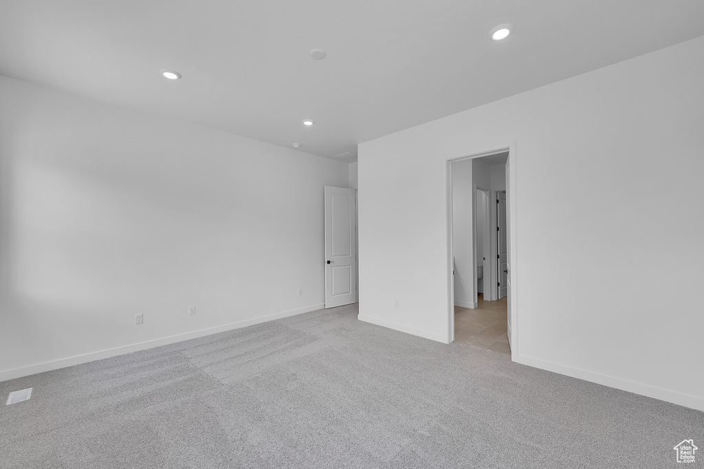 Empty room with light carpet, recessed lighting, and baseboards