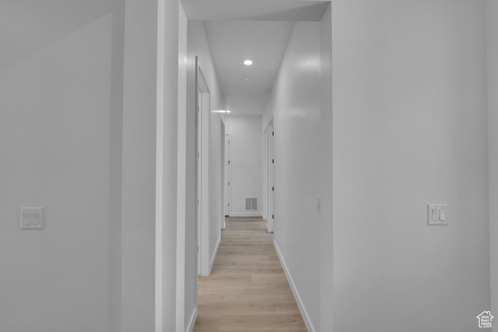 Hall with recessed lighting, light wood-style floors, and baseboards