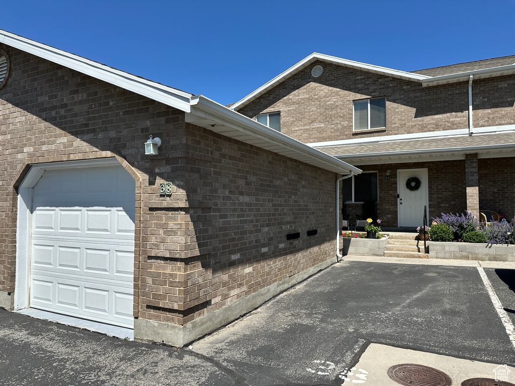 View of property exterior with a garage and brick siding