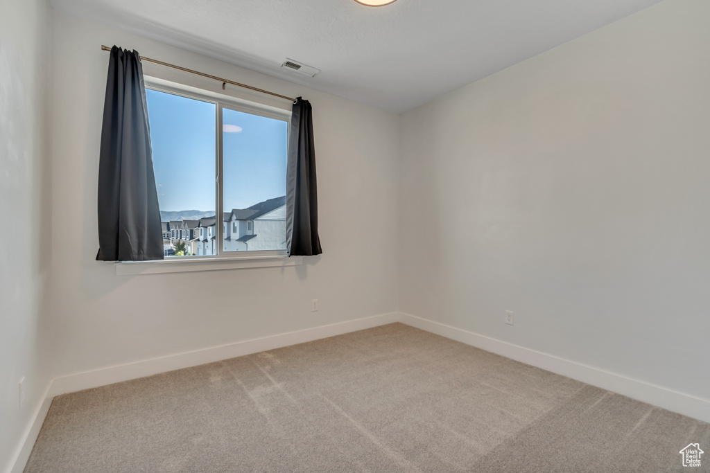 Carpeted empty room with baseboards