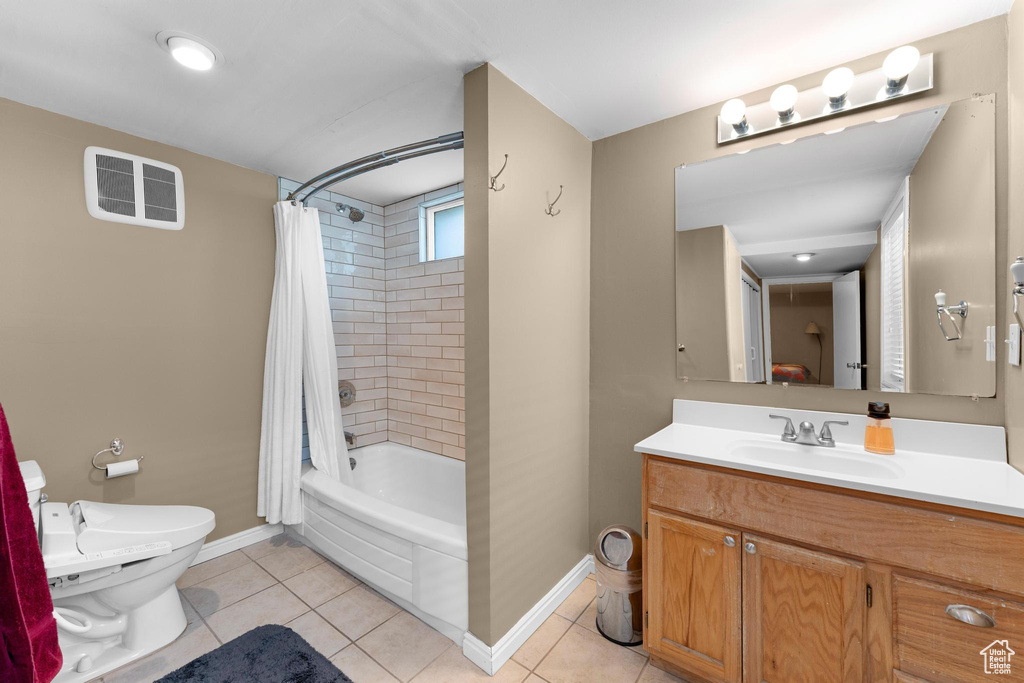 Full bath featuring toilet, baseboards, vanity, shower / tub combo, and tile patterned flooring