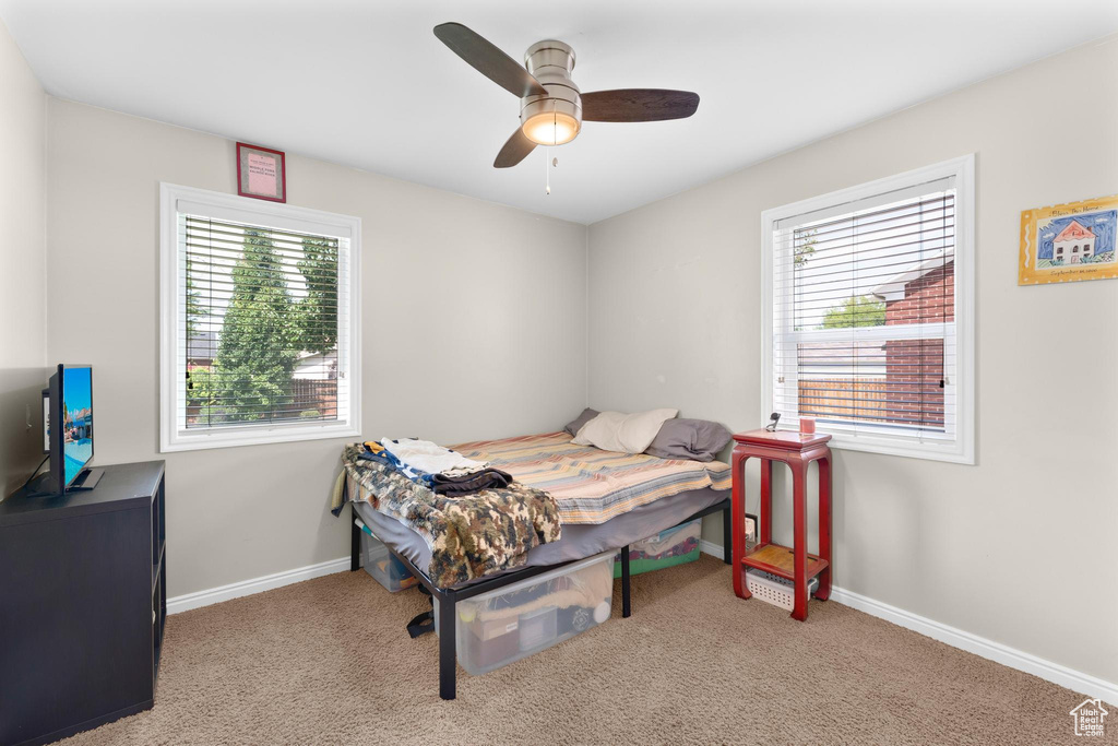 Carpeted bedroom with baseboards and a ceiling fan