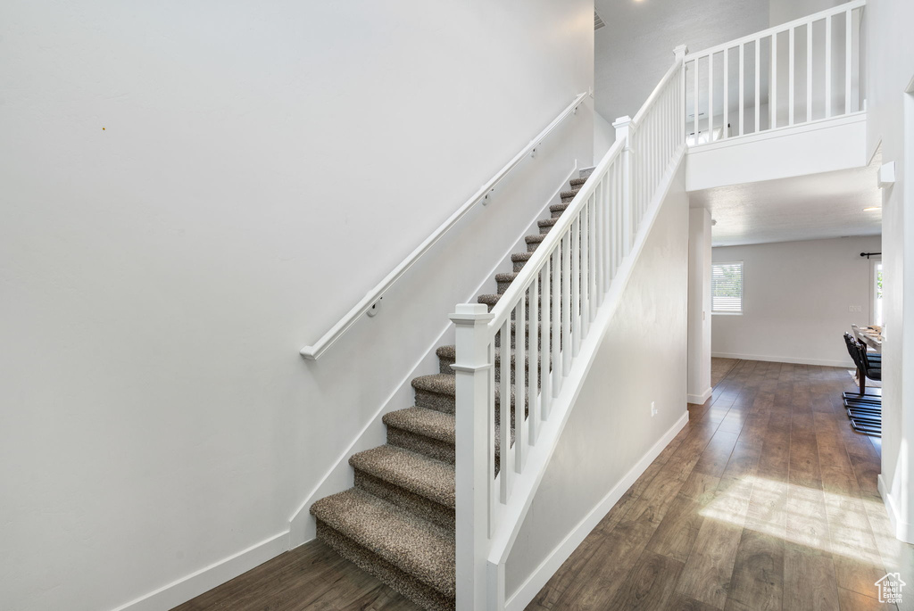 Stairs with wood finished floors and baseboards