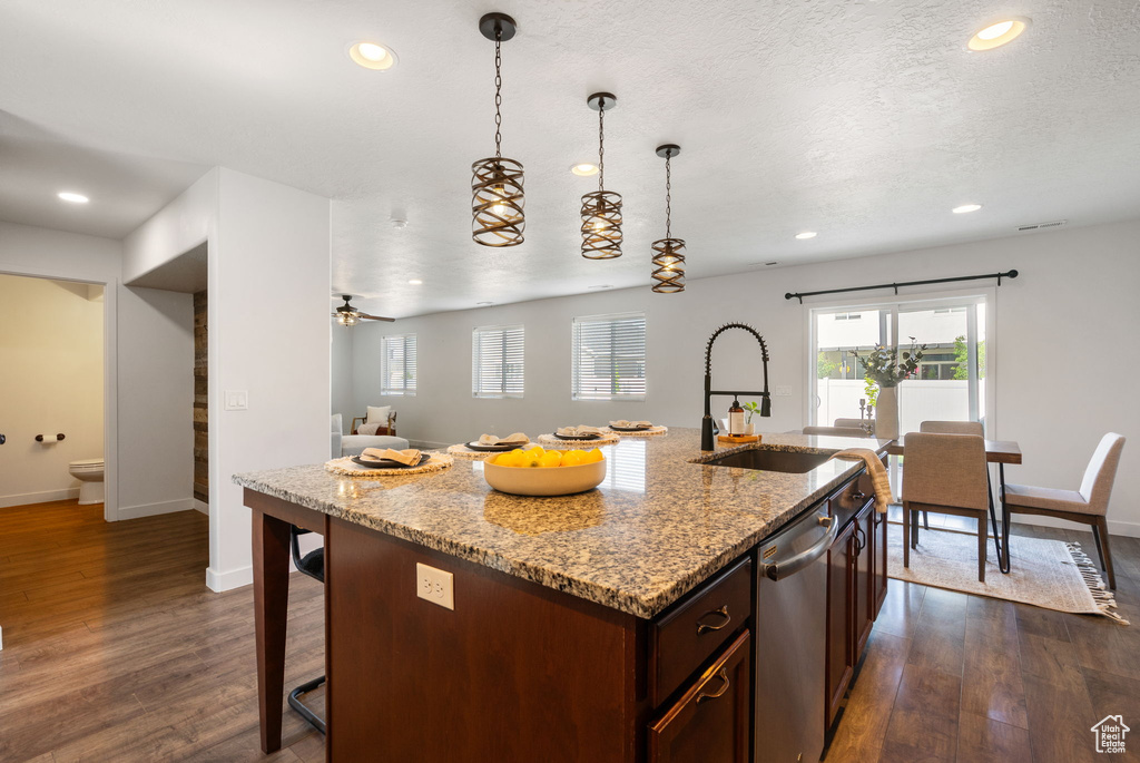Kitchen with a sink, stainless steel dishwasher, baseboards, recessed lighting, and dark wood-style floors