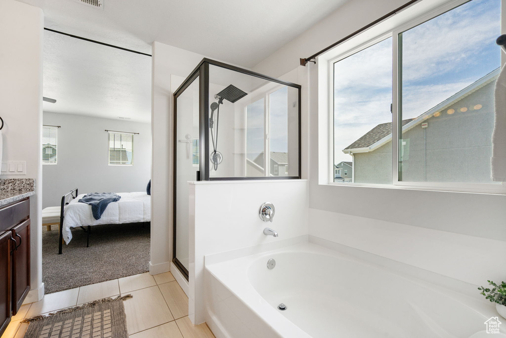 Bathroom featuring a shower stall, a bath, vanity, tile patterned floors, and connected bathroom