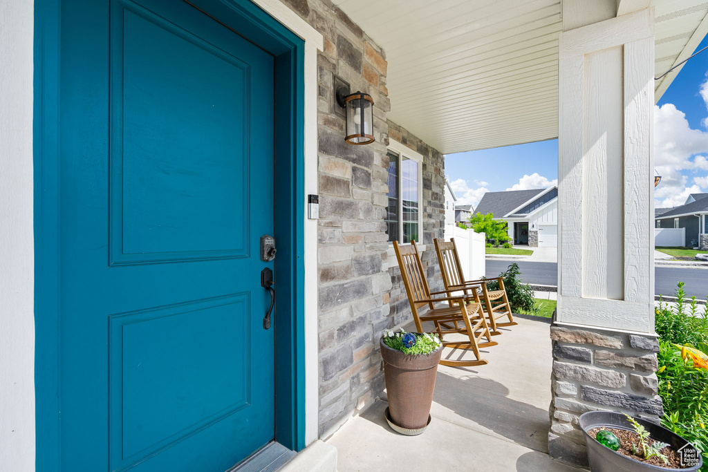 Doorway to property with a porch and stone siding