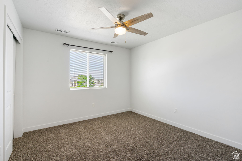 Unfurnished bedroom featuring carpet floors, a closet, baseboards, and ceiling fan
