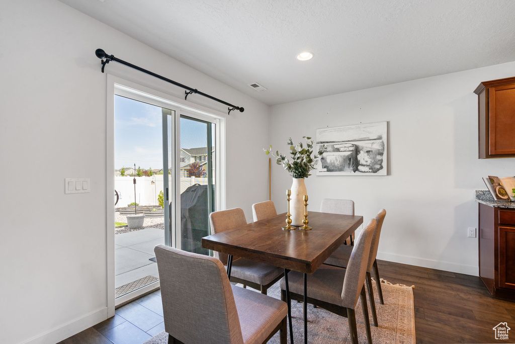 Dining room featuring dark wood finished floors, baseboards, and recessed lighting