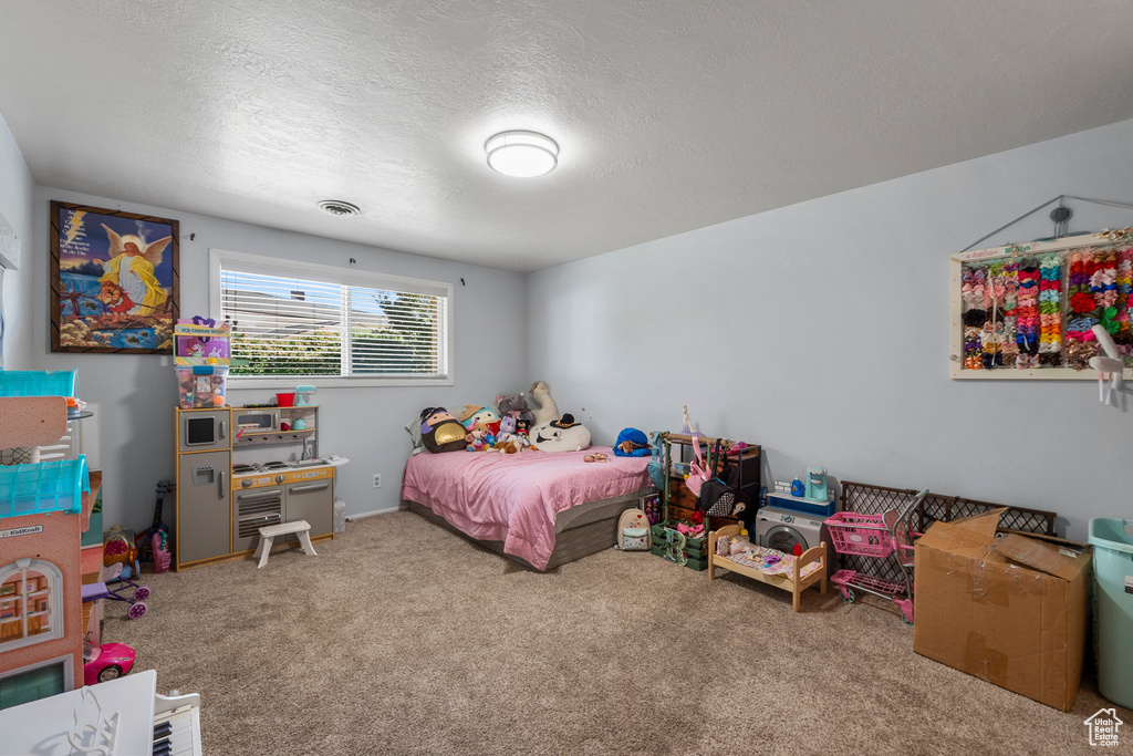 Bedroom with carpet floors and a textured ceiling