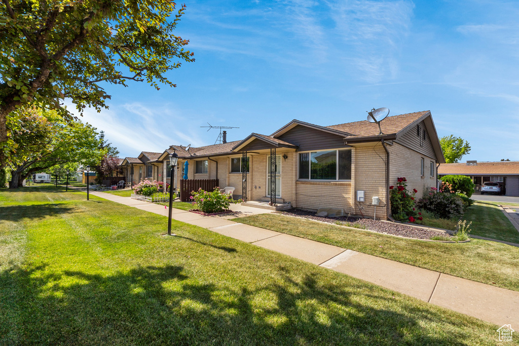 Ranch-style home featuring a front yard and brick siding
