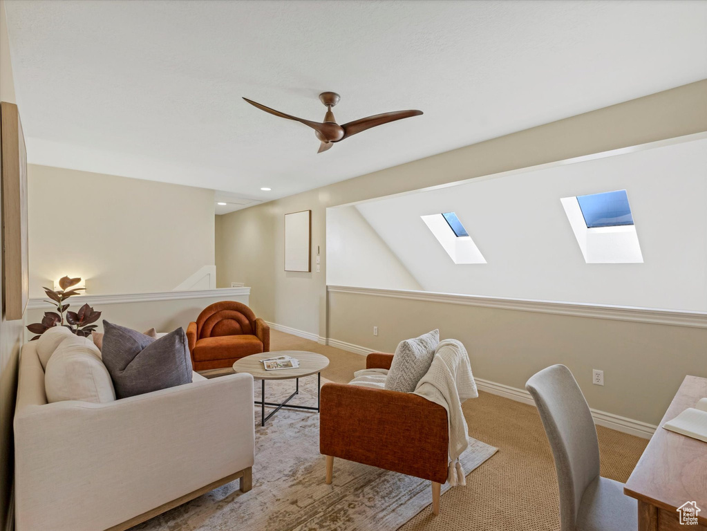 Living area with a skylight, recessed lighting, ceiling fan, baseboards, and carpet flooring