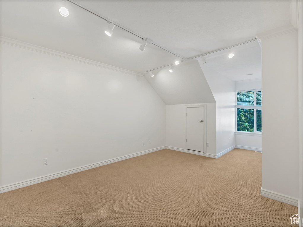 Bonus room featuring light colored carpet, baseboards, and lofted ceiling