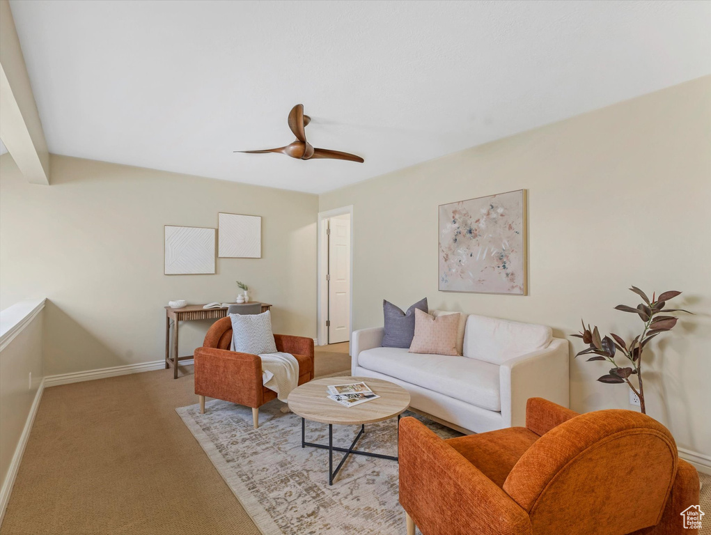 Living room featuring carpet floors, baseboards, ceiling fan, and beamed ceiling