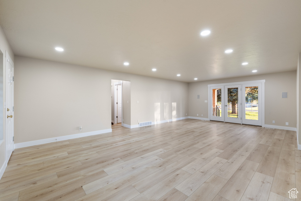 Unfurnished living room with recessed lighting, light wood-type flooring, and baseboards