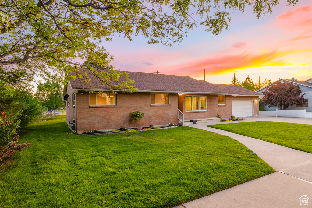 Single story home featuring brick siding, an attached garage, driveway, and roof with shingles