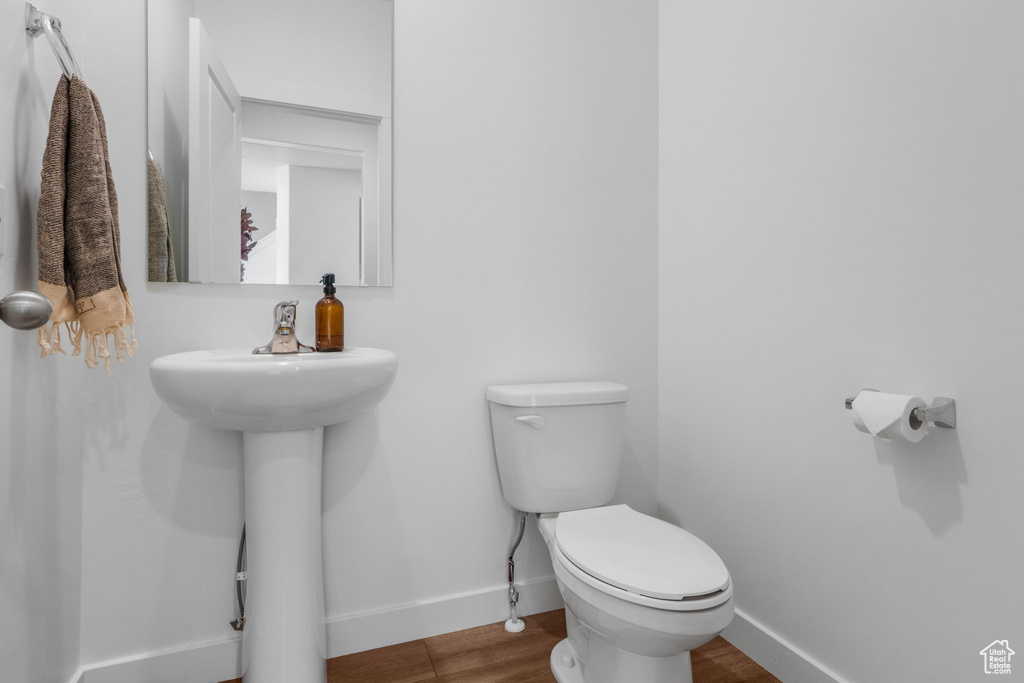 Bathroom with baseboards, toilet, and wood finished floors