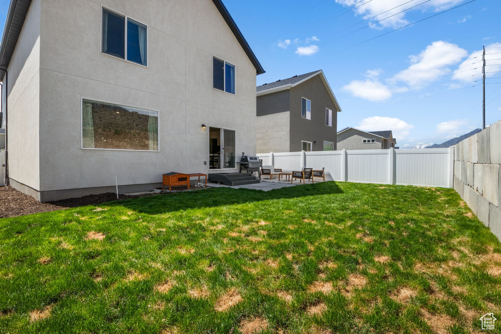 Rear view of house with stucco siding and a patio area