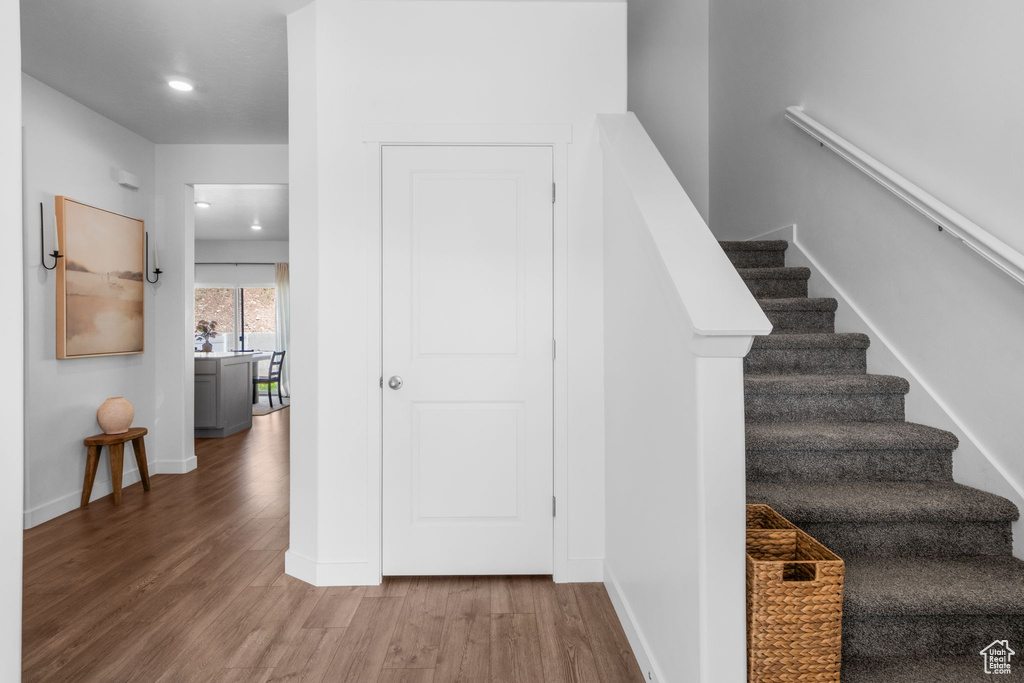 Stairway featuring wood finished floors, recessed lighting, and baseboards