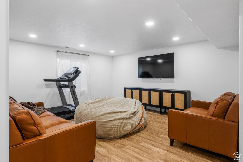 Living area with light wood-style flooring and recessed lighting