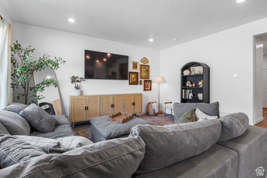 Living area with recessed lighting, wood finished floors, and baseboards