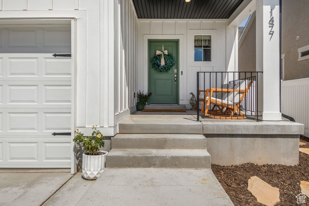 Entrance to property with an attached garage and board and batten siding