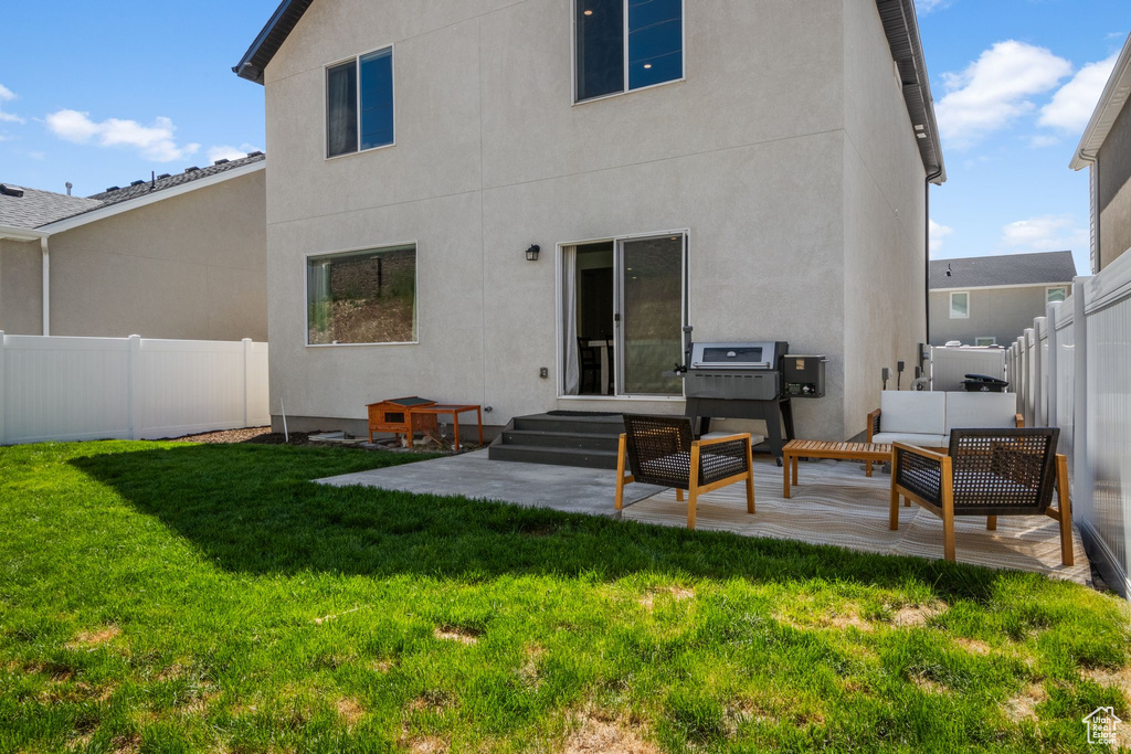 Rear view of house with stucco siding, a patio, and an outdoor living space