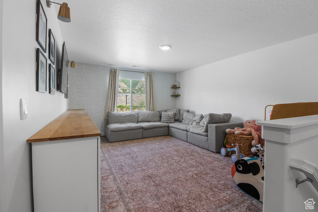 Living area with carpet and wallpapered walls