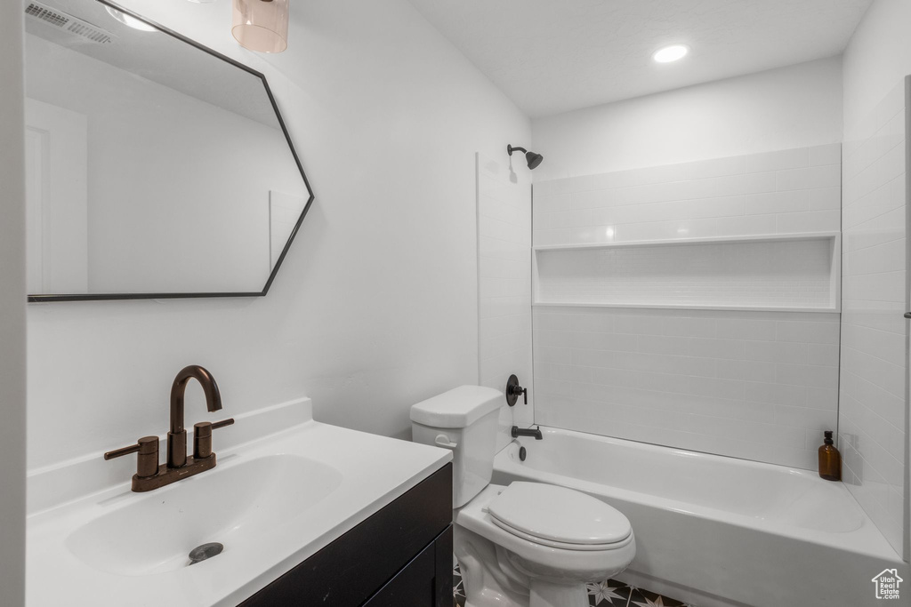 Full bath featuring washtub / shower combination, vanity, toilet, and recessed lighting