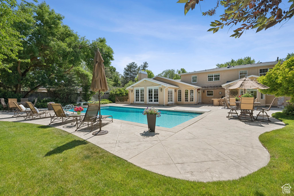 View of swimming pool with french doors and a patio