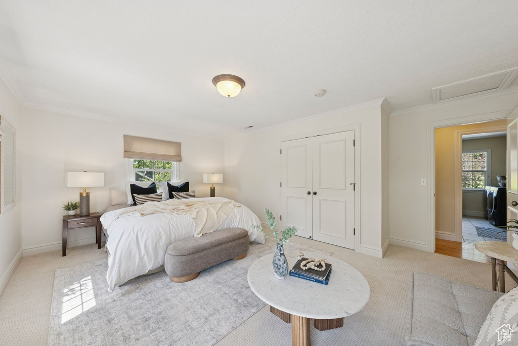 Bedroom featuring light colored carpet, baseboards, attic access, a closet, and ornamental molding