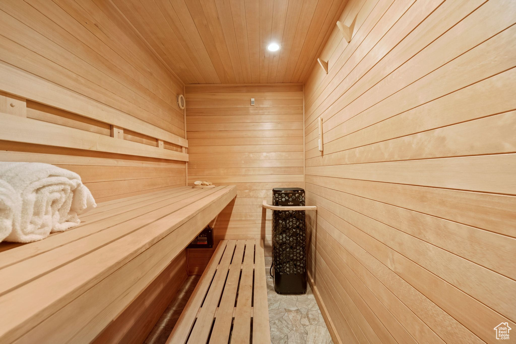Sauna with wooden walls, wooden ceiling, and recessed lighting