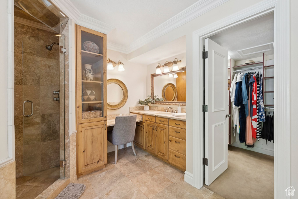 Bathroom with vanity, a stall shower, a spacious closet, and crown molding