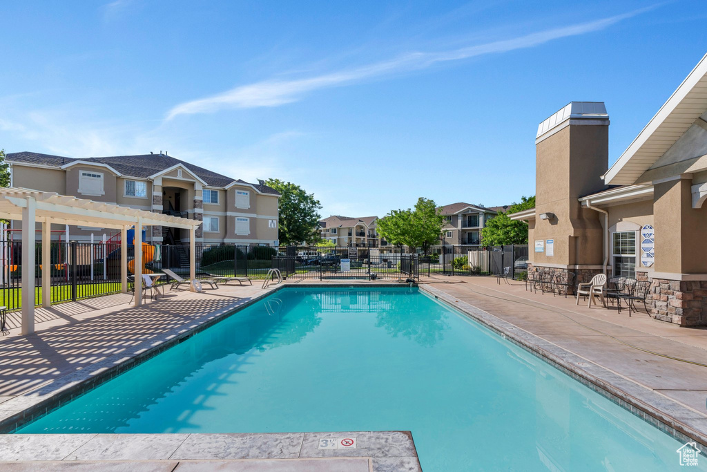 Community pool with a residential view, a pergola, and a patio area