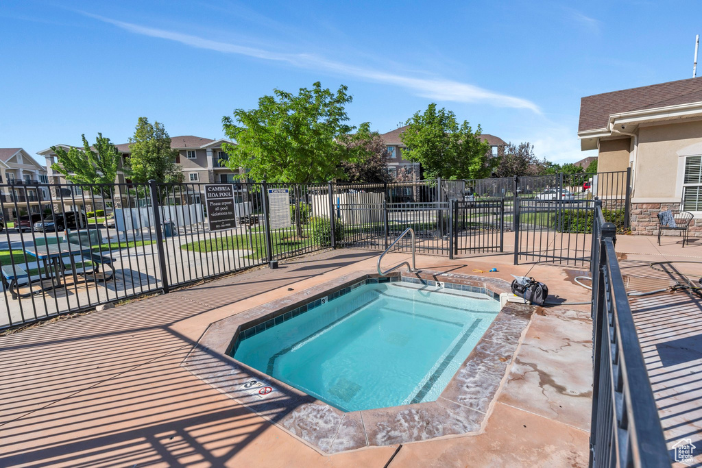 View of swimming pool featuring a community hot tub and a residential view