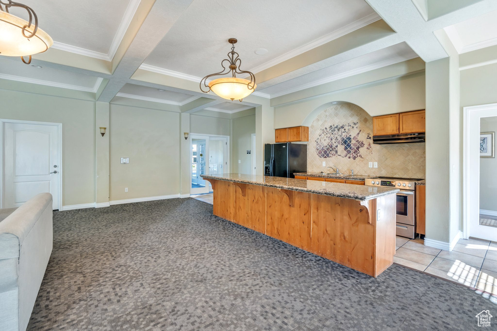 Kitchen with black fridge, stainless steel electric range oven, ventilation hood, crown molding, and a kitchen bar