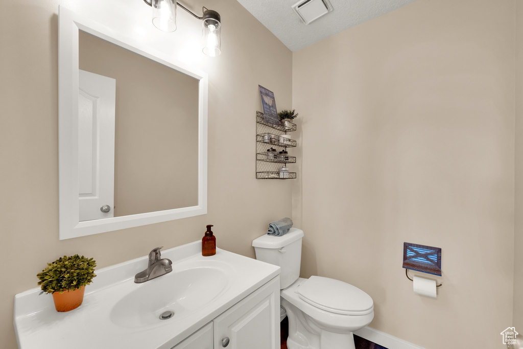 Half bathroom with vanity and toilet