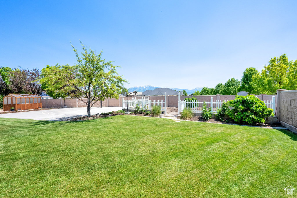 View of yard featuring a mountain view, an outbuilding, and a patio