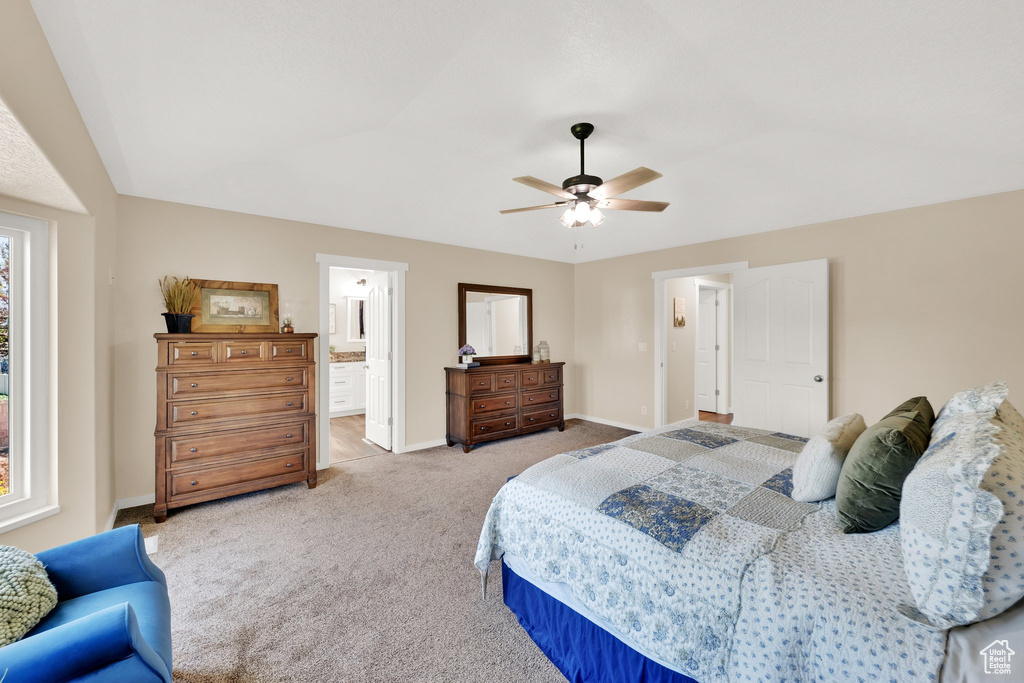 Bedroom with light carpet, baseboards, a ceiling fan, and connected bathroom